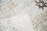 Hand-knotted backing and distressed Oushak pile with a faint tribal star.