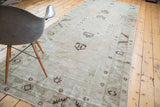 Distressed Oushak runner with faded geometric stars and serrated border in light green.