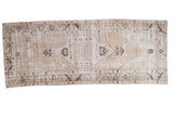 Distressed Oushak runner, hand knotted with faded apricot, moss, and ivory geometric tribal patterns.