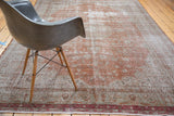 Distressed Oushak carpet with a heavily worn texture and faded brown, green hues.