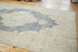 Distressed denim blue field with softened ivory border and detailed powder blue motifs.
