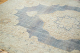 Vintage Oushak rug's distressed denim blue field with softened ivory medallion and trefoil.