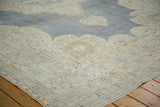 Softened ivory border with muted trefoil and floral motifs on distressed Oushak rug.