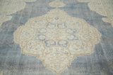 Distressed denim blue Oushak field with softened ivory medallion and powder blue trefoil.
