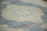 Distressed denim blue and softened ivory Oushak carpet showing intricate medallion and trefoil motifs.