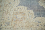 Distressed vintage Oushak rug showing softened ivory, denim blue, and light bark brown design elements.