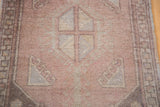 Hand-knotted Oushak rug detail showcasing dusty rose field with silver grey geometric motifs.