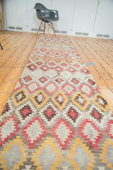 Colorful geometric diamond lattice on vintage Kilim runner in saffron, blush, and grey.