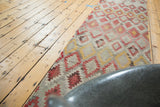 Geometric diamond lattice on vintage Turkish Kilim runner in saffron, pink, and ivory tones.