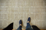 Distressed modern abstract Oushak rug, ivory and charcoal geometric pattern, feet for scale.