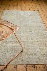 Modern distressed Oushak rug section, featuring faded ivory geometric patterns and subtle charcoal lines.