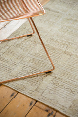 Distressed vintage Oushak rug texture with abstract ivory and sage geometric patterns.