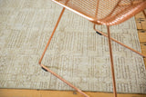 Distressed Oushak rug, close-up of abstract geometric pattern in faded ivory and charcoal.