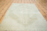 Faded platinum Oushak rug with distressed texture and subtle tribal design.