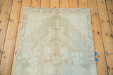 Distressed geometric stepped medallion and tribal border on a silver Oushak rug.