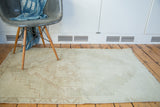 Distressed hand knotted Oushak rug with faded geometric pattern, subtle platinum and beige tones.