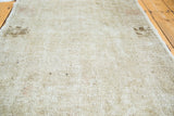 Distressed vintage Oushak rug showing aged patina, silver, platinum, and charcoal floral renderings.