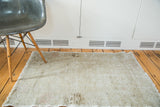 Aged silver and platinum distressed Oushak rug with rose hues and charcoal floral accents.