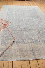 Distressed pile texture of an Oushak rug, showing faded slate blue floral palmettes.