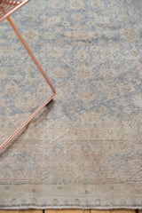 Distressed Oushak carpet showing muted slate blue, beige, and ivory floral palmettes.