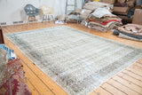 Faded, distressed Khorassan carpet featuring allover peach, beige, and blue paisley design.