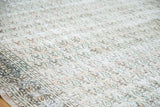 Distressed vintage Khorassan rug detail, featuring faded peach and blue paisley patterns.