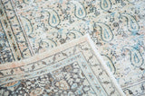 Distressed vintage Khorassan carpet with faded paisley field and vine border in peach and sky blue.