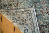 Distressed, hand-knotted pile texture and woven edge of vintage slate blue Oushak rug.