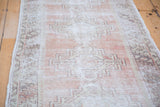 Distressed Oushak runner with soft texture, faded brick red, and grey geometric medallions.