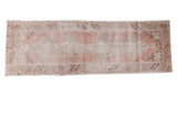 Faded brick red distressed Oushak runner with geometric medallions and grey spandrels, 3' x 9'.