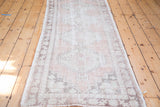 Faded blush rose field with stepped geometric medallions on a distressed vintage Oushak rug.