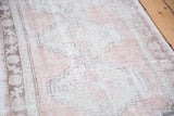 Faded blush rose and beige tones with geometric stepped motifs on a distressed vintage Oushak runner.