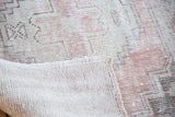 Faded blush and grey distressed Oushak runner pile, revealing its hand-knotted foundation.