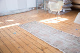 Vintage Oushak runner, full length, with distressed texture and faded blush rose field.