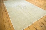 Subtle faded motifs and soft distressed texture on the light ivory beige Oushak rug.