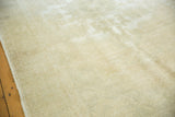 Faded design and distressed pile texture on a light ivory beige Oushak rug.