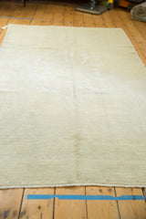 Distressed hand-knotted Oushak rug with soft ivory beige field and subtle oversized medallion.