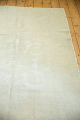 Hand-knotted distressed pile texture in ivory and beige tones on a Turkish Oushak rug.