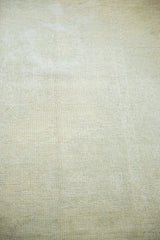 Distressed Oushak rug's textured pile in light ivory and soft beige tones.