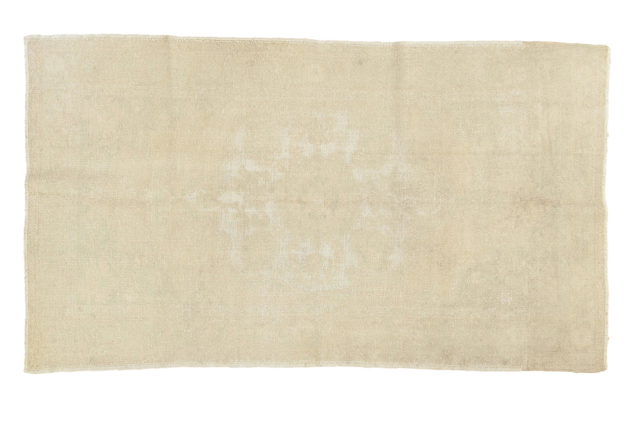 Distressed hand-knotted Oushak rug featuring a faded scalloped medallion on ivory, 4'6