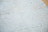 Detail of the distressed texture and subtle aqua and light bronze abrashes on the Oushak rug.