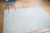 Light-toned hand-knotted foundation of the distressed Oushak rug, with faint blue lines.