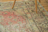Intricate faded red medallion with gold, charcoal green on a distressed Oushak rug.
