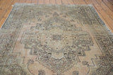 Distressed pile texture with intricate geometric medallion on the dusty beige Oushak carpet.