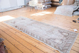 Distressed Oushak runner end, highlighting muted tones and geometric striped border.