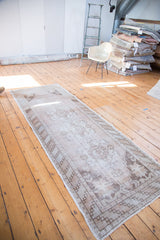 Faded Turkish Oushak runner with a distressed quadruple medallion pattern.