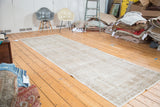 Subtle faded texture of the distressed Oushak runner in light apricot, beige, and silver.