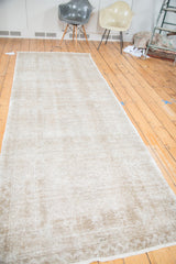 Distressed hand-knotted pile of a vintage Oushak runner in faded beige, silver, and apricot.