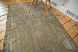 Distressed texture and muted geometric patterns of the neutral Oushak rug.