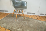 Textured distressed Oushak rug, showcasing faded neutral charcoal and silver geometric patterns.